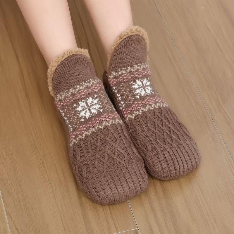 Brown Christmas plush socks with snowflake pattern worn on feet
