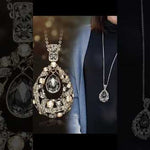 Elegant blue spinel teardrop pendant necklace, featuring a sparkling oval gemstone, surrounded by a halo of glittering rhinestones, close-up view of hand-held display