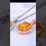 Product demonstration video of elegant yellow citrine halo pendant necklace. Video showcases the vibrant oval-cut yellow citrine center stone surrounded by brilliant cubic zirconia crystals, available in both sterling silver and rose gold plated options. Features close-up views of the gemstone clarity, halo design details, delicate chain, and secure clasp closure. Perfect for birthdays, anniversaries, and special occasions.
