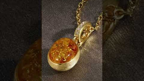 Product demonstration video of natural amber stone pendant necklace featuring genuine amber gemstone with warm golden honey tones set in luxurious gold plated frame. Video showcases the unique organic patterns within the amber stone, elegant gold plated setting with decorative bail, lightweight design, and versatile styling options. Perfect gift for gemstone lovers and nature enthusiasts.

